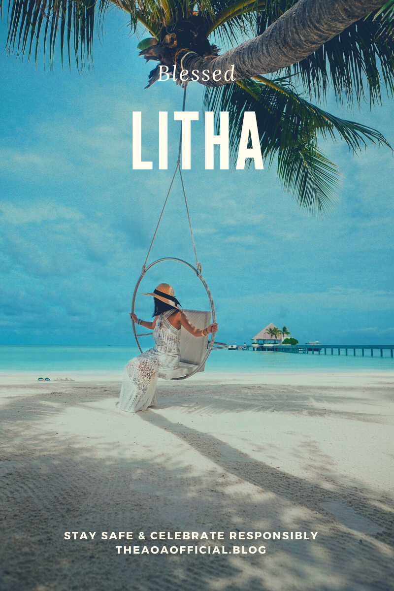 Person sitting on a beach swing hanging from a palm tree in the daytime looking out over the nearby ocean. There's white sand beneath them and blue sky and water behind them. In the distant background there is a tropical hut out on the water, connected to the beach by a foot bridge. Overlaid is the message, "Blessed Litha. Stay safe and celebrate responsibly." theaoaofficial.blog